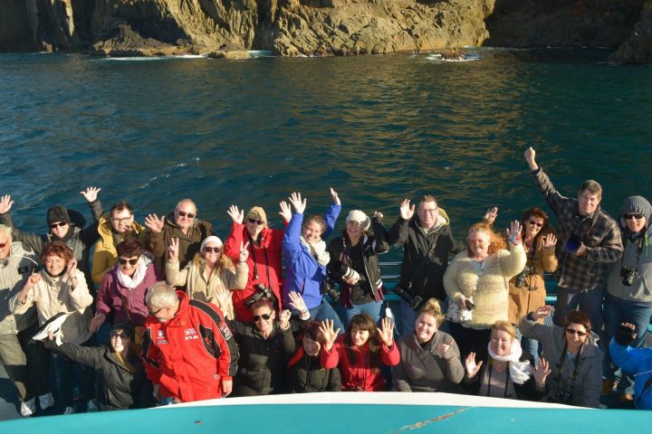 a group of people posing for a photo in front of water
