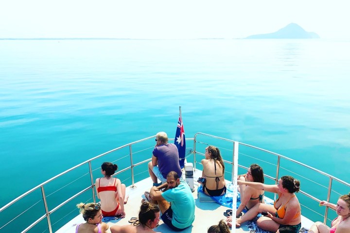a group of people sitting in front of a body of water