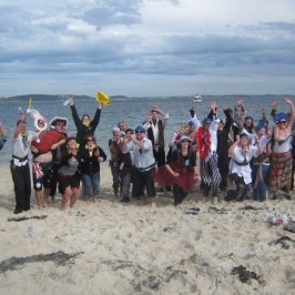 a group of people standing on top of a sandy beach