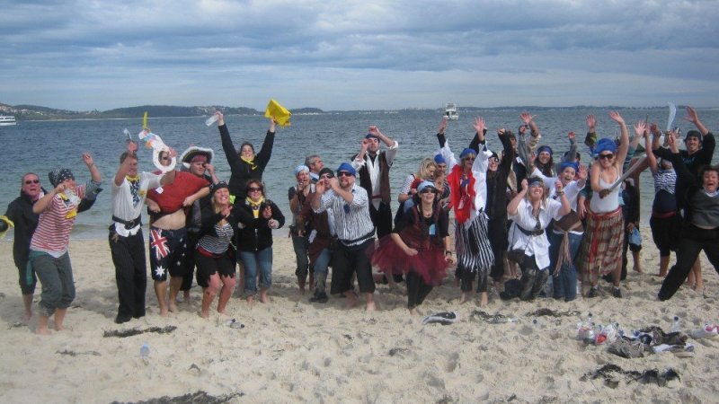 Moonshadow-TQC-Cruises-Team-Building-Photos-58-1000px a group of people standing on top of a sandy beach