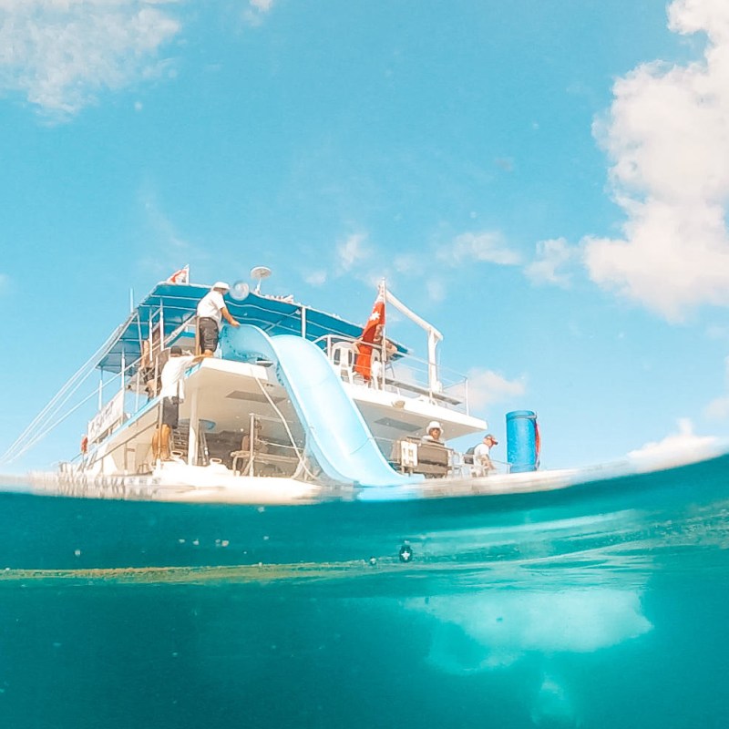 a blue and white boat sitting next to a body of water