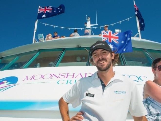 a man standing on a boat posing for the camera
