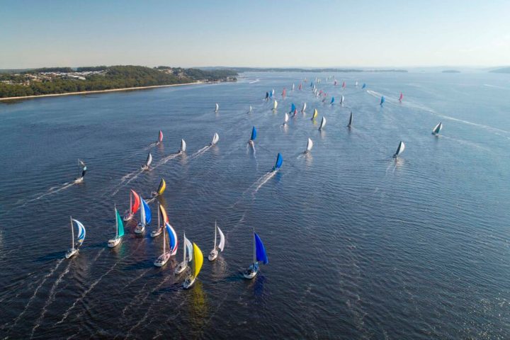 a group of people flying kites in a body of water