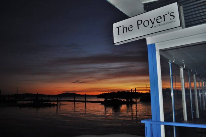 a sign in front of a sunset