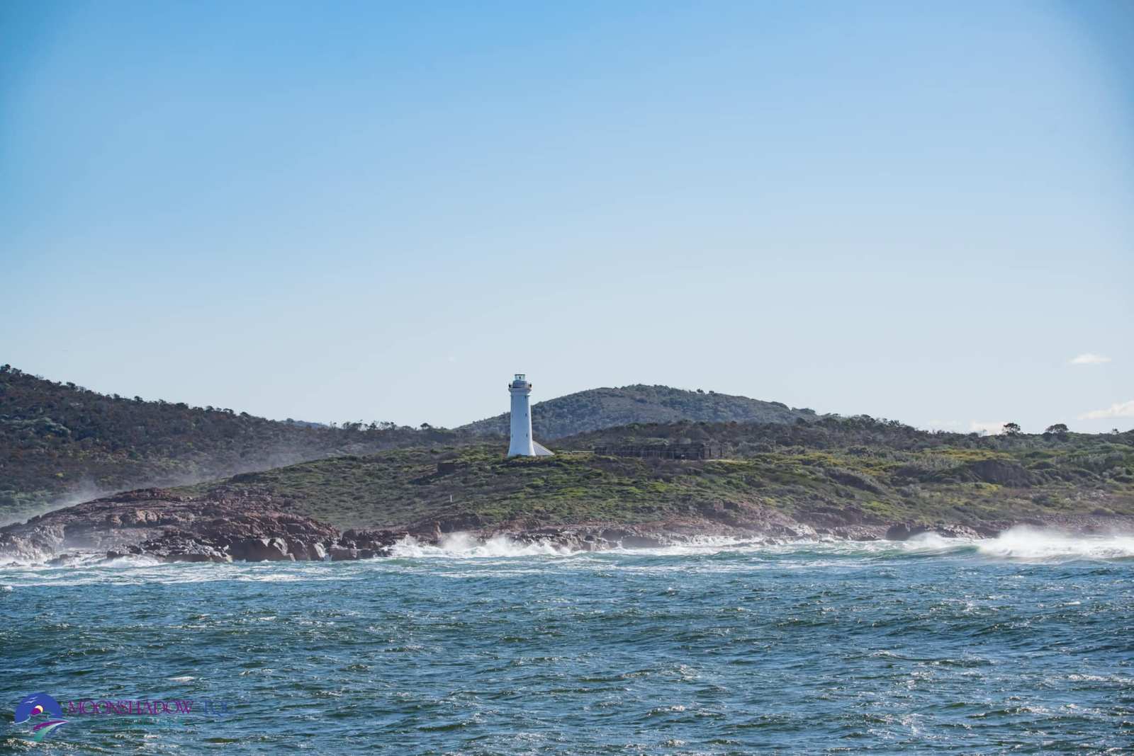 a large body of water with a mountain in the background