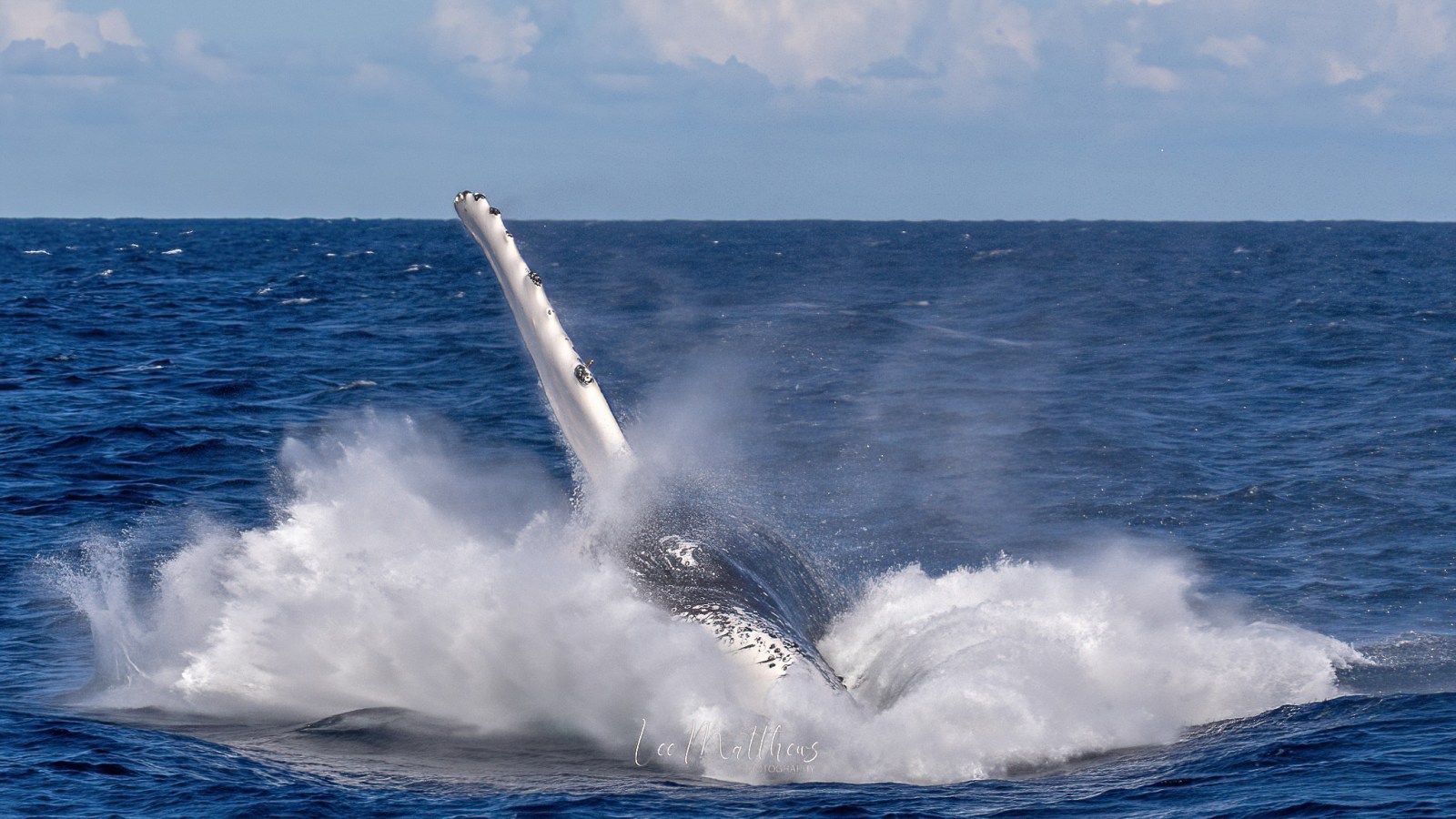a man flying through the air while riding a wave in the ocean